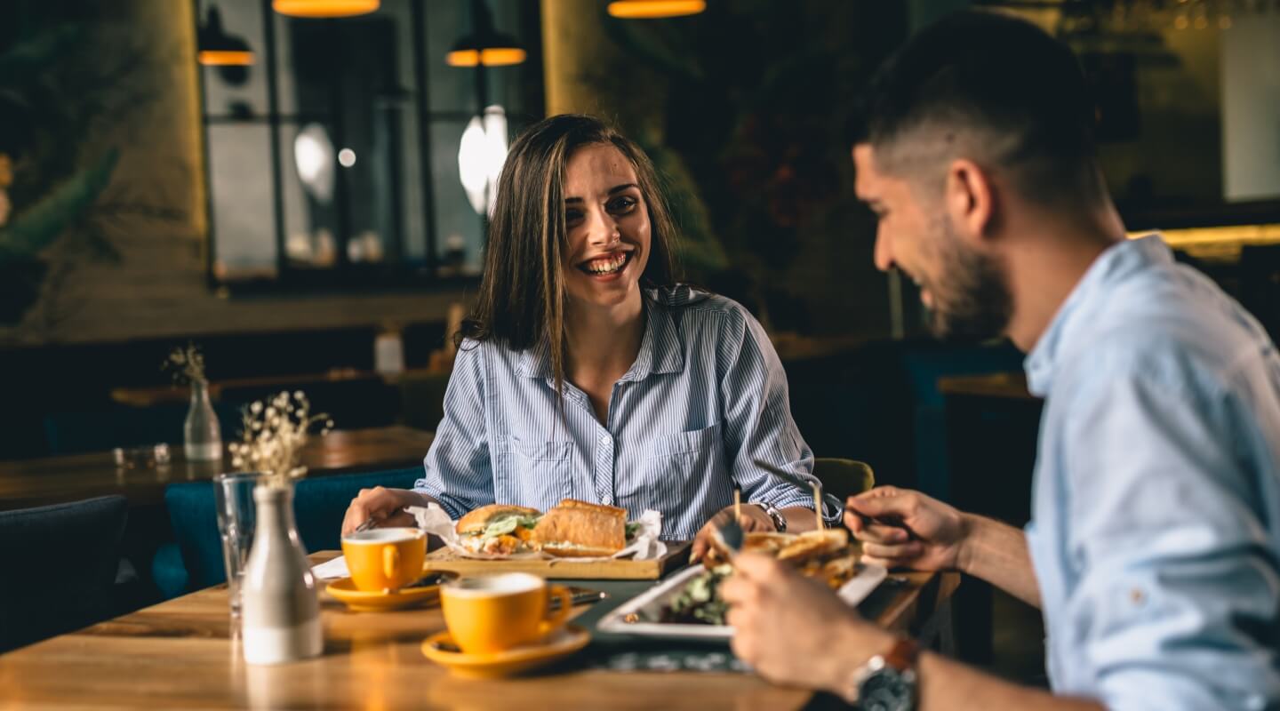 a couple out to dinner and the woman is smiling