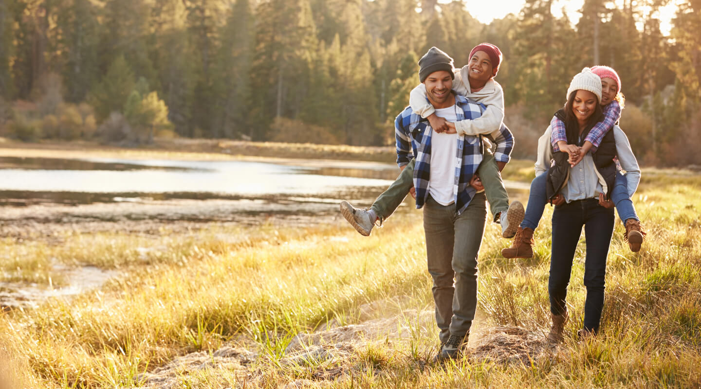 a family of four hiking along a stream